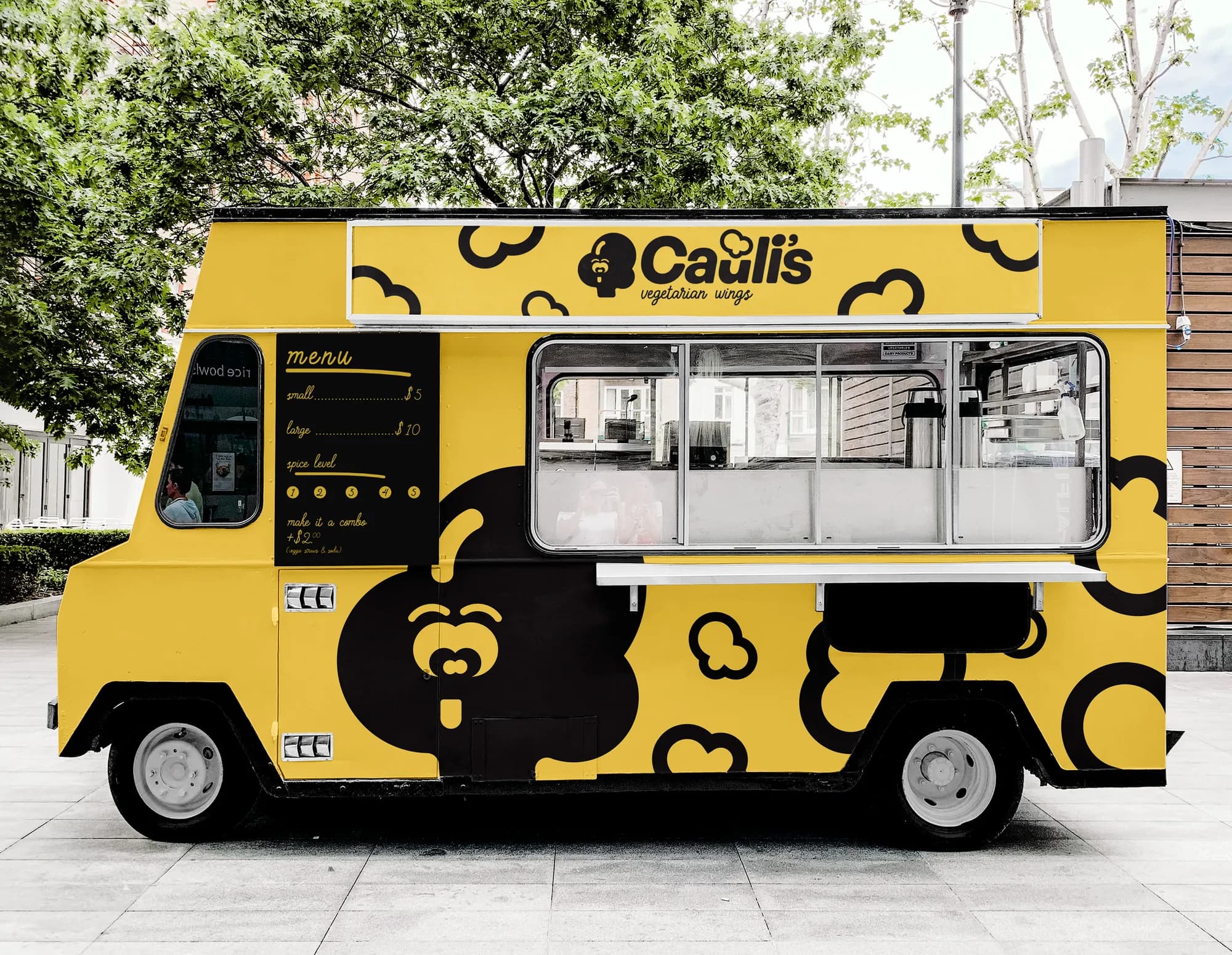 The Cauli’s food truck: a bright yellow truck covered in cauliflower icons, with a big cauliflower face and a hand-lettered menu.