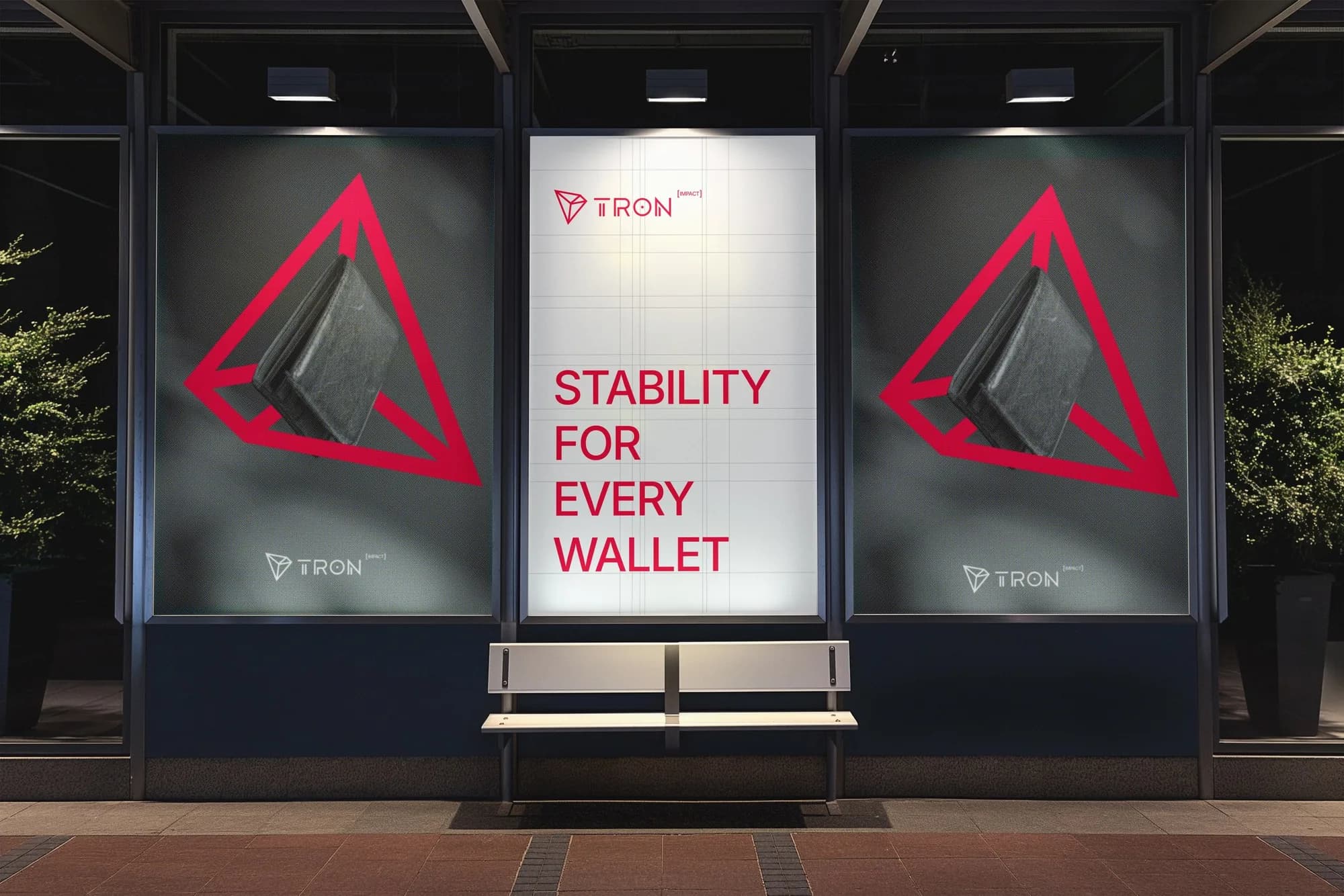 A bus stop lightbox at night with the TRON mark and Stability for Every Wallet.