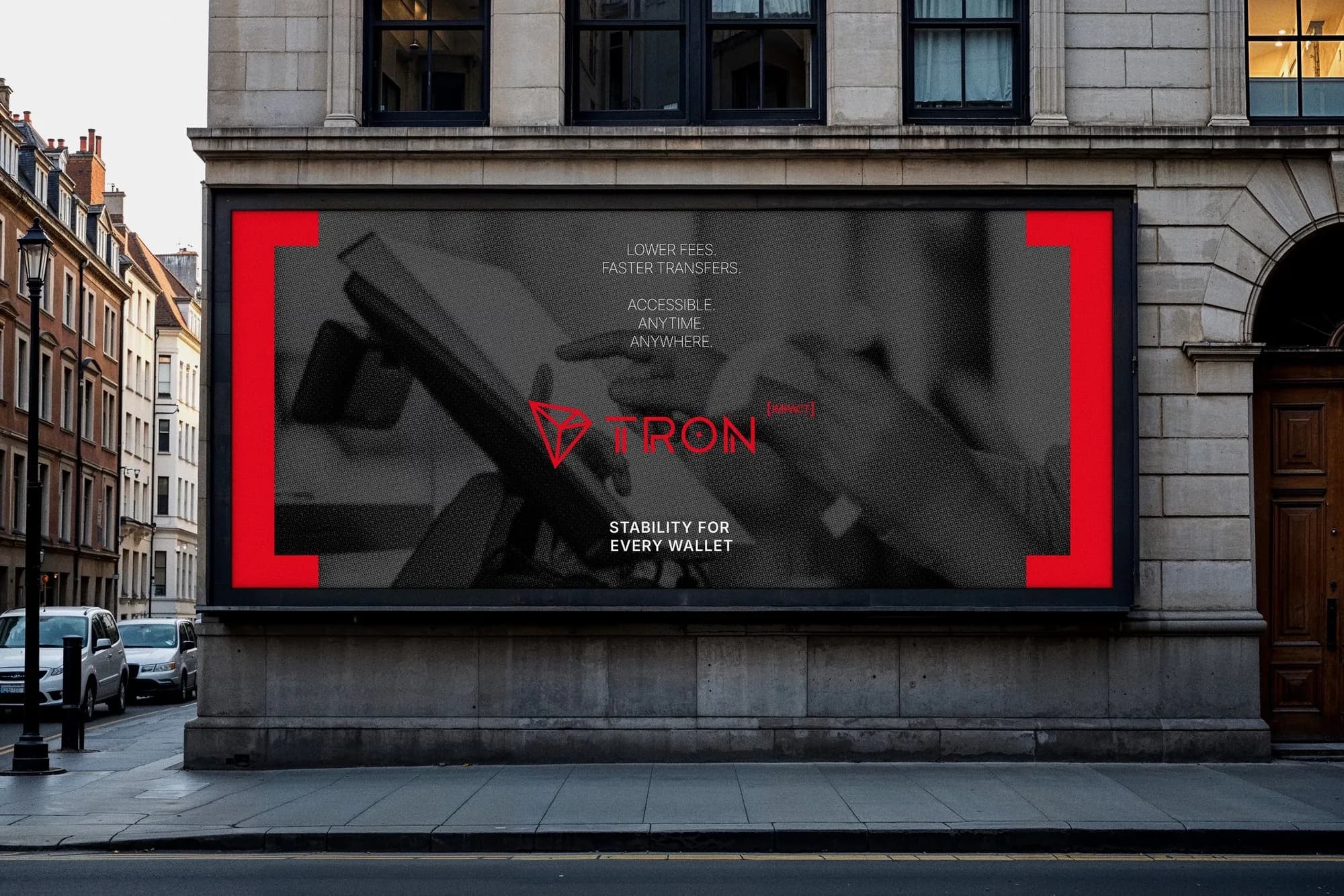 A wide TRON IMPACT poster framed by red brackets on a stone building front.